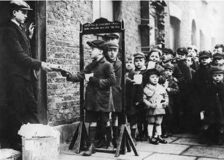 1930年代，伦敦东区的孩子们排队等待慈善组织发放小礼品包