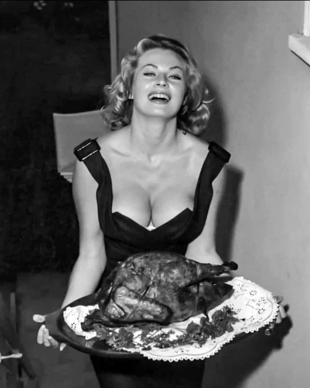 #名人 瑞典女演员Anita Ekberg在1958年由著名摄影师Andre de Dienes拍摄的一张照片中，正为大家端上感恩节晚餐