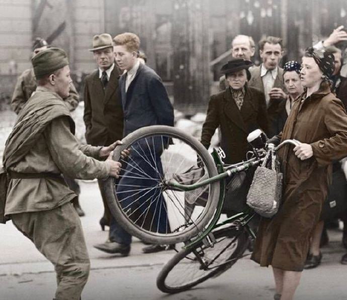 1945年，苏联红军士兵试图从一名德国妇女那里抢一辆自行车