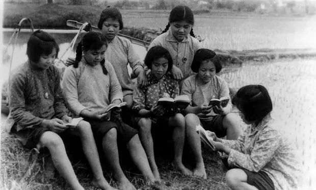 1970年，中国广西，农民在水稻种植休息期间学习毛主席在小红书上的语录