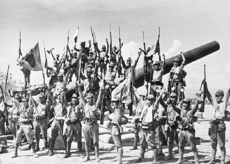 1942 年，日本占领菲律宾，日本兵在缴获的美国大炮前拍照庆祝