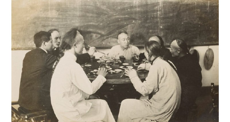 1908年，浙江杭州，一群男子围坐在饭桌旁就餐