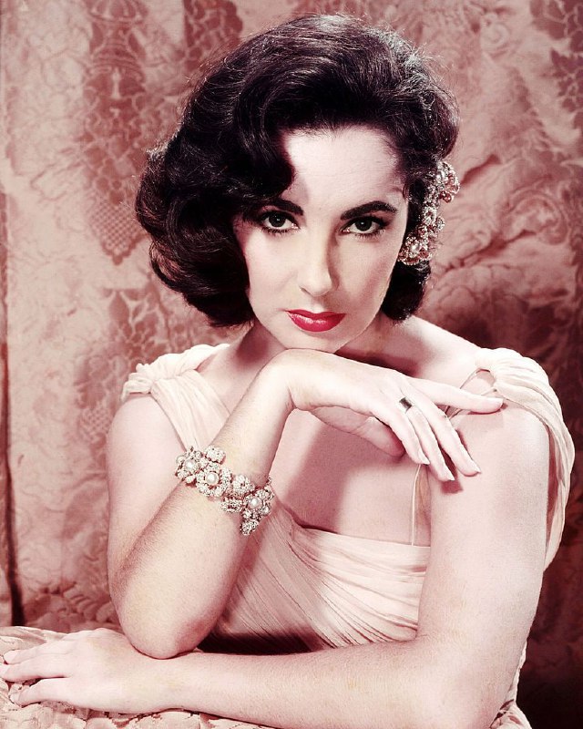 #名人 英国出生的美国女演员伊丽莎白·泰勒（Elizabeth Taylor，1932 年 - 2011 年），身穿晚礼服，佩戴珍珠手链，摄于 1955 年左右